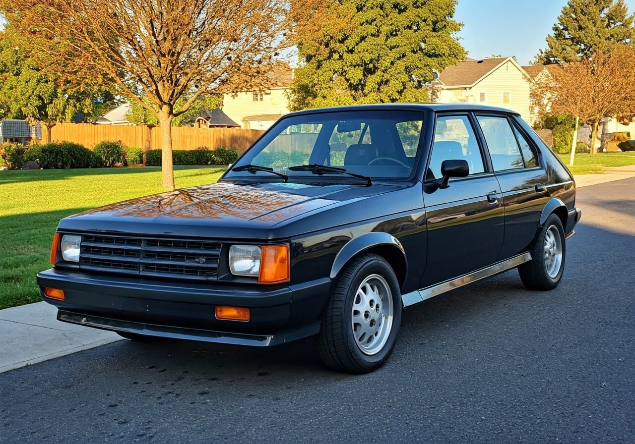 Sleek 1986 Dodge Omni GLH on Retrofuturistic Driveway