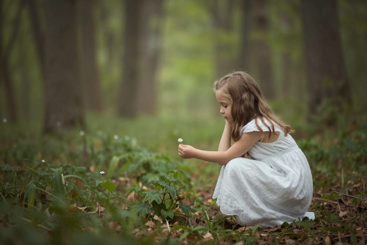 Dreamy Forest Scene: Girl Contemplates Flower