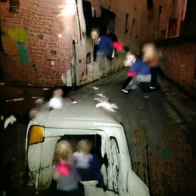 Children Ejecting Adults from Van in Alleyway