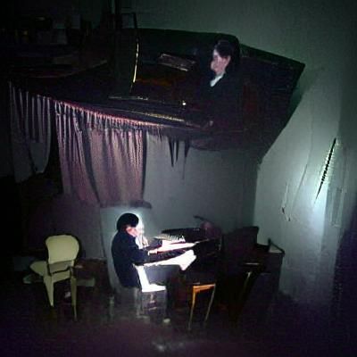 Man Playing Piano in Dark Room