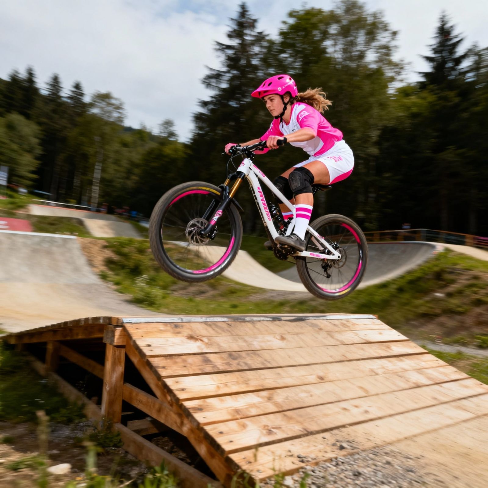 Female Mountain Biker Jumps Wood Drop in Bike Park