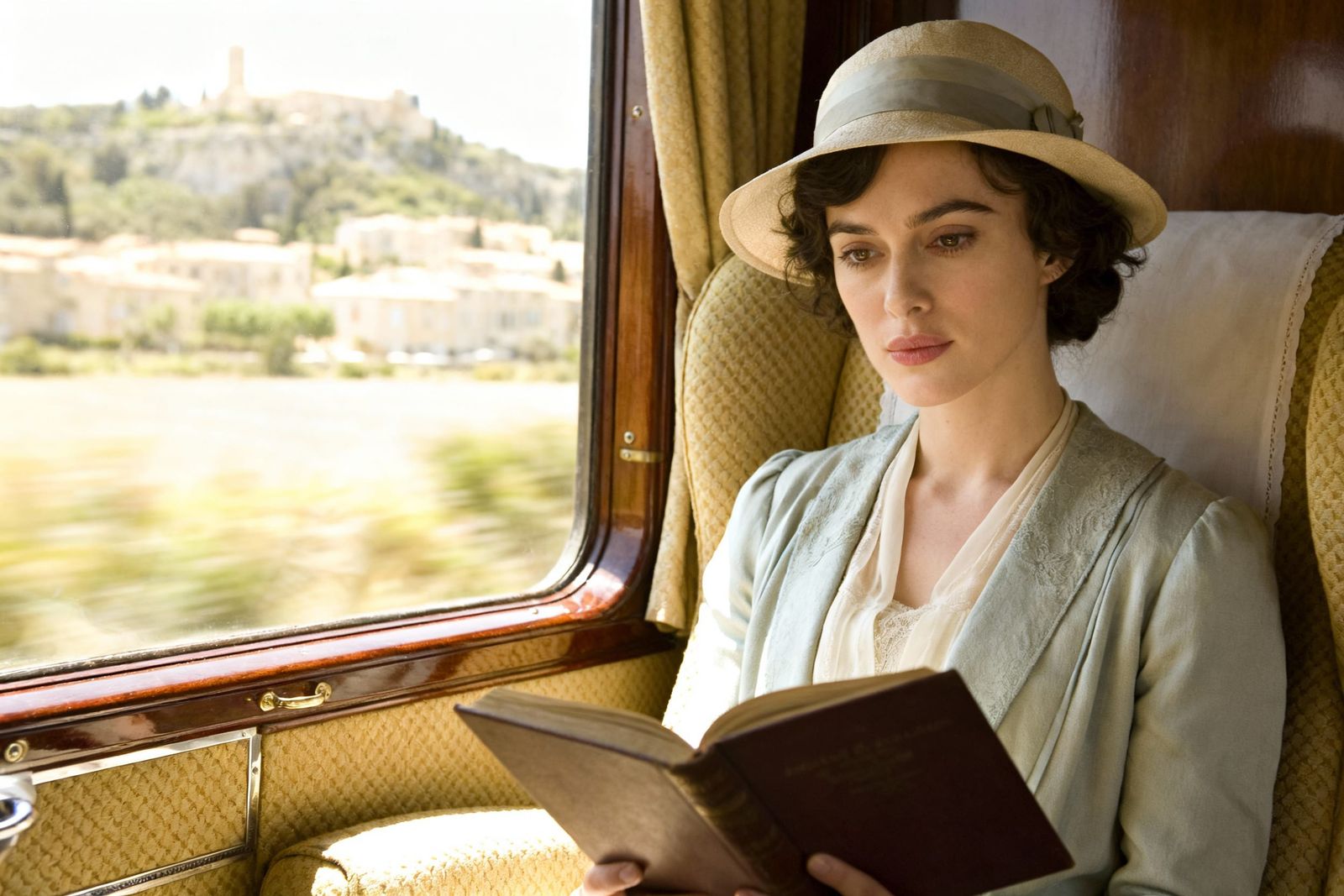 Elegant Woman Reads in Vintage Train Compartment
