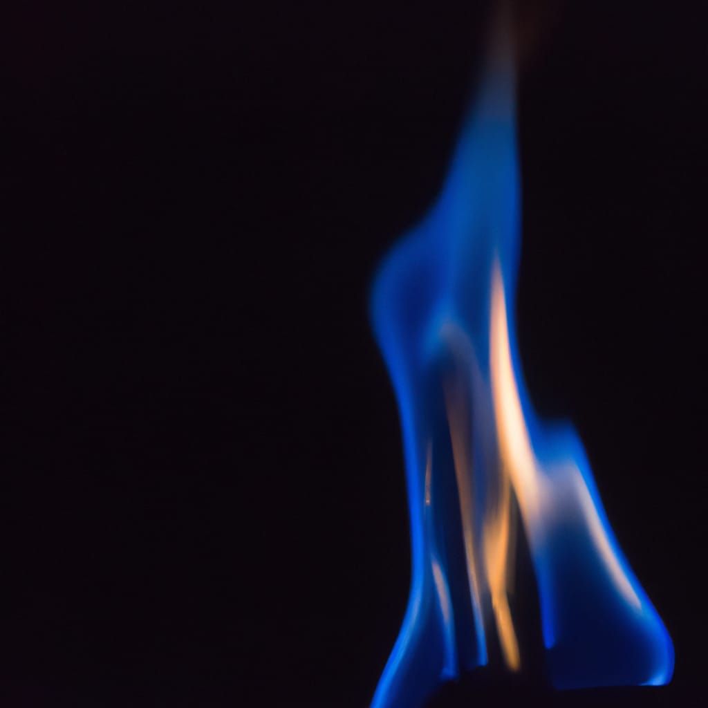 Vibrant Blue Flame Ignites with Golden Tip on Dark Backgroun...