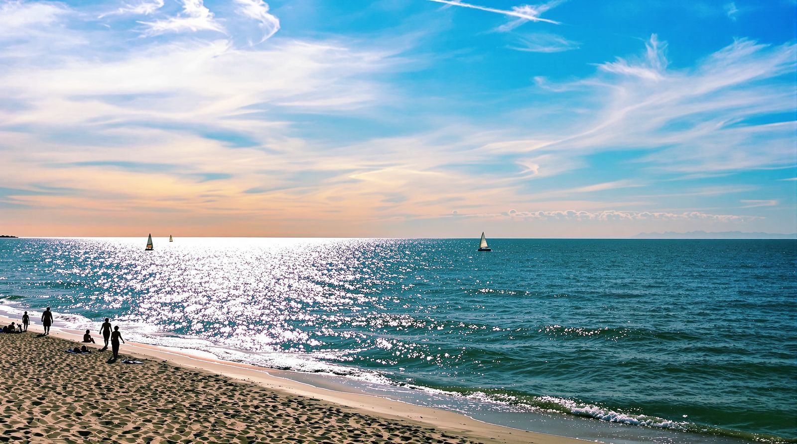 Sparkling Sunset Over Shimmering Sea and Sandy Shore