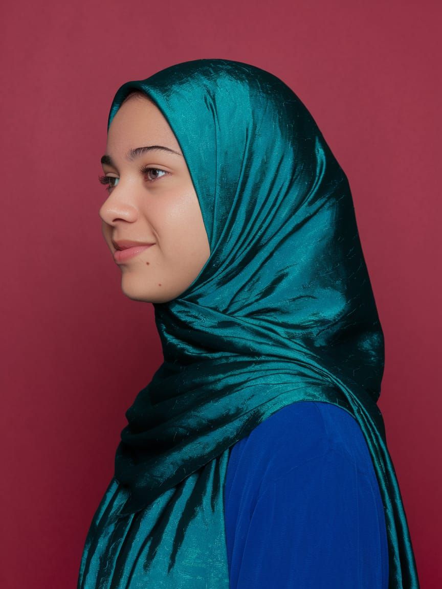 Profile Portrait in Teal Hijab on Red Background