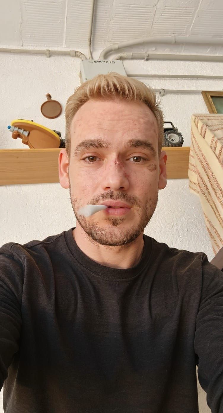 Blonde Man Poses for Selfie While Smoking
