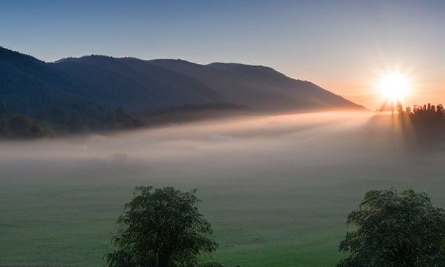 Sunrise Valley: A Misty Morning Landscape
