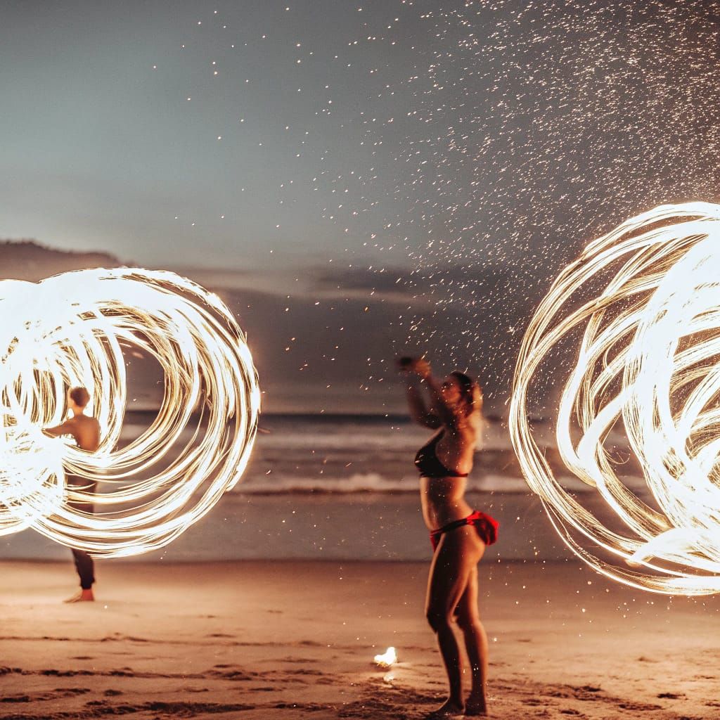 Glowing Fire Dancer on Night Beach with Time-Lapse Sky