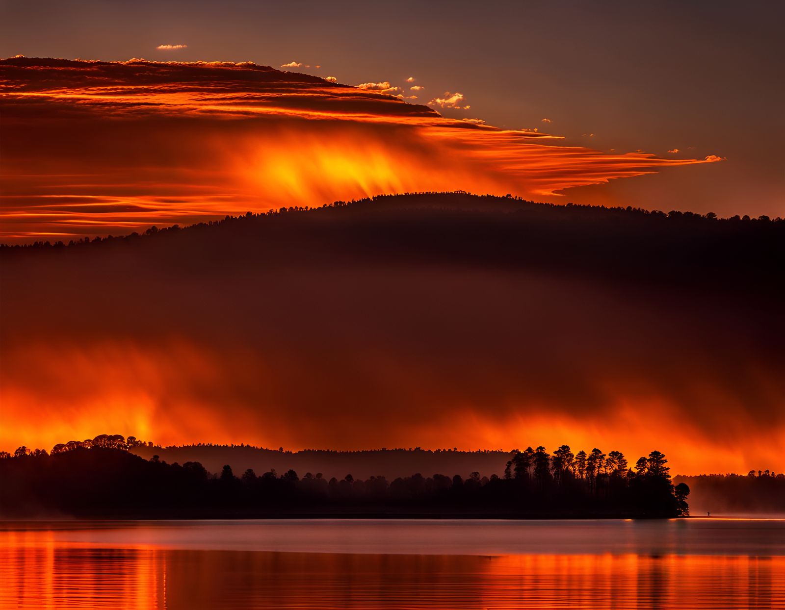 A brilliant orange sky,  dawn orange horizon over an  lake floodlit from bellow the water with  heavy intense orange sea...
