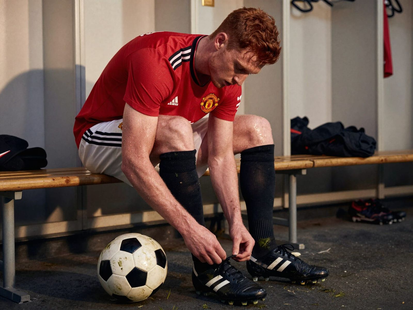 Soccer Player Untying Cleats in Locker Room