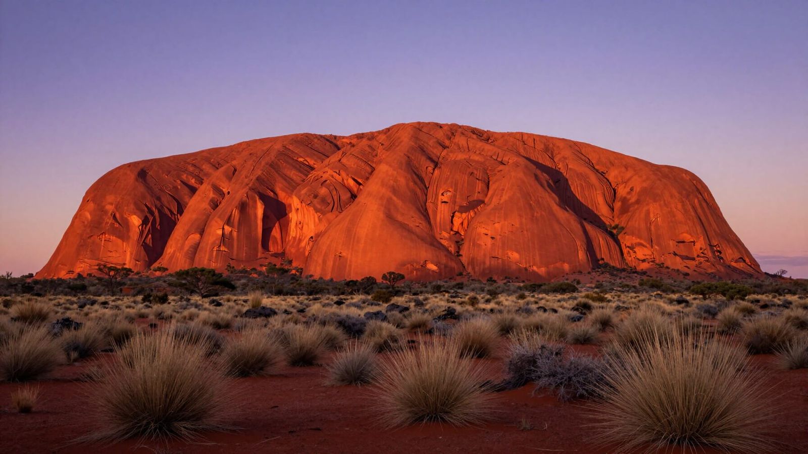 Hyper-realistic wide shot of Uluru at sunrise