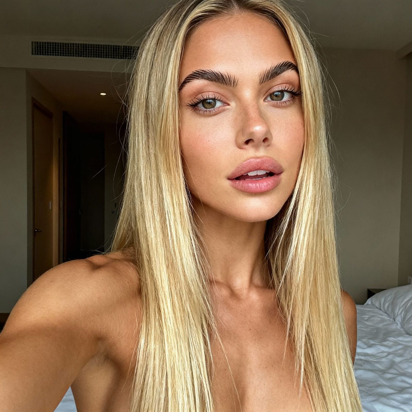 Blonde Woman Takes Selfie in Bedroom