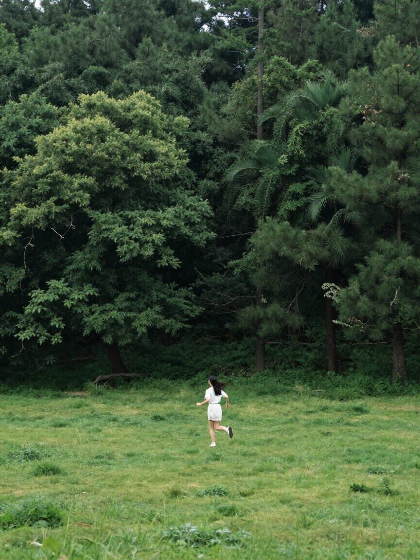 Girl Running Through Lush Forest Landscape