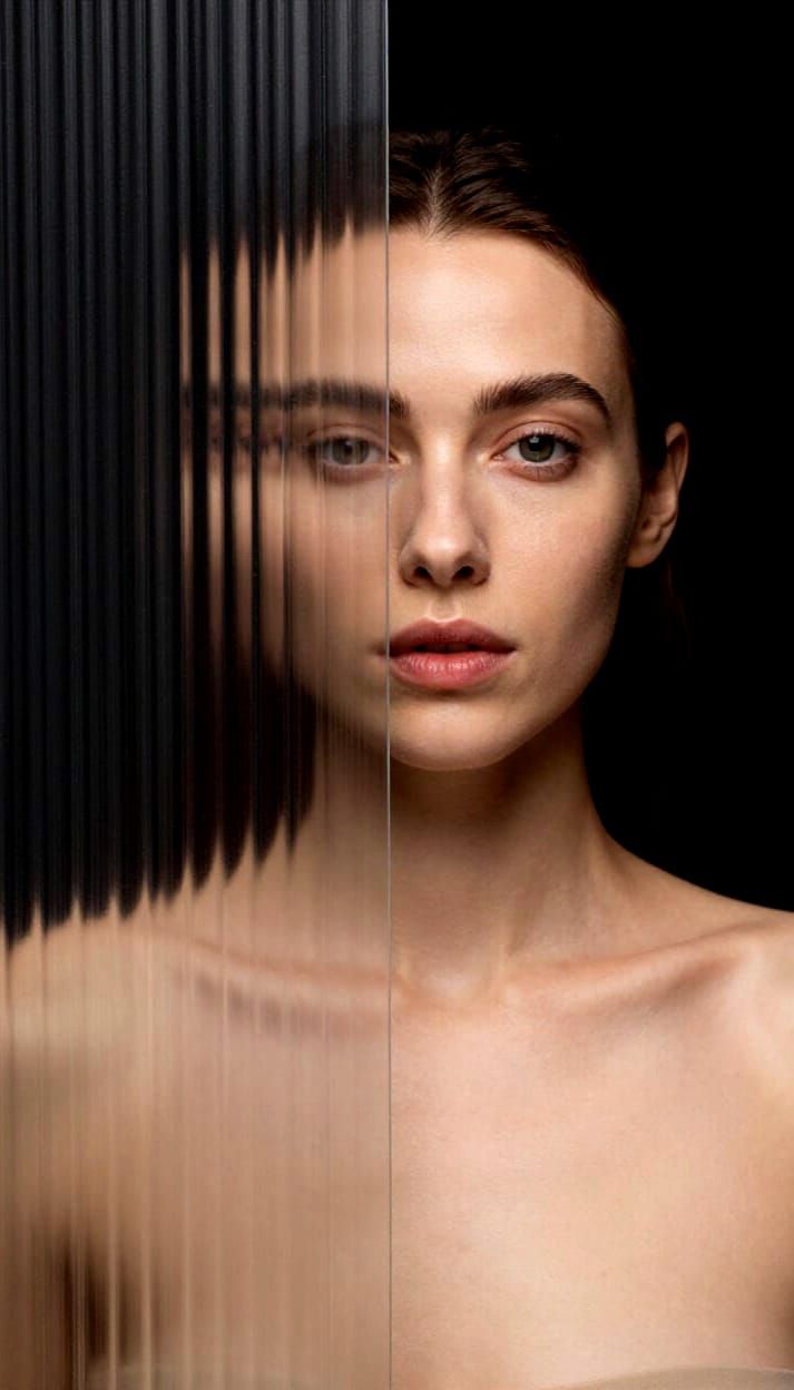 Woman's Face Distorted by Ribbed Glass Refraction