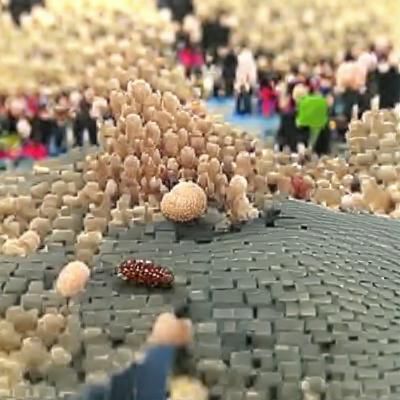 Miniature People Swarm a Colossal Giant