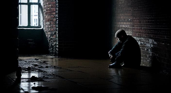 Solitary Figure in Dimly Lit, Decaying Room