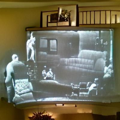 Man Watching 1930s Movie on Big Screen TV