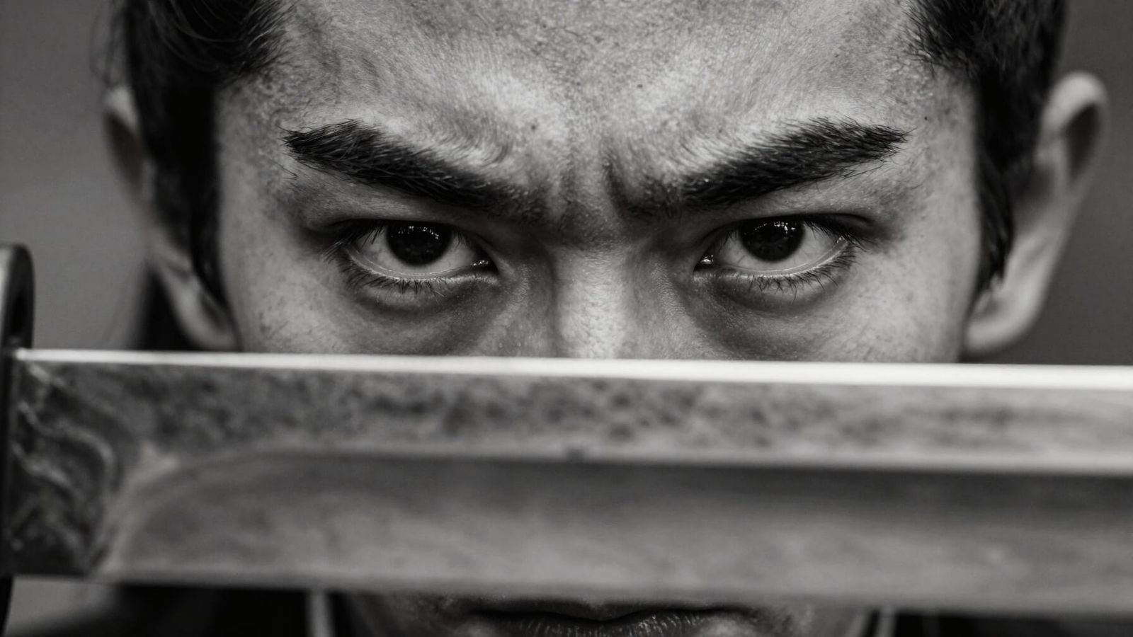 Warrior's Intense Gaze Over Reflective Blade