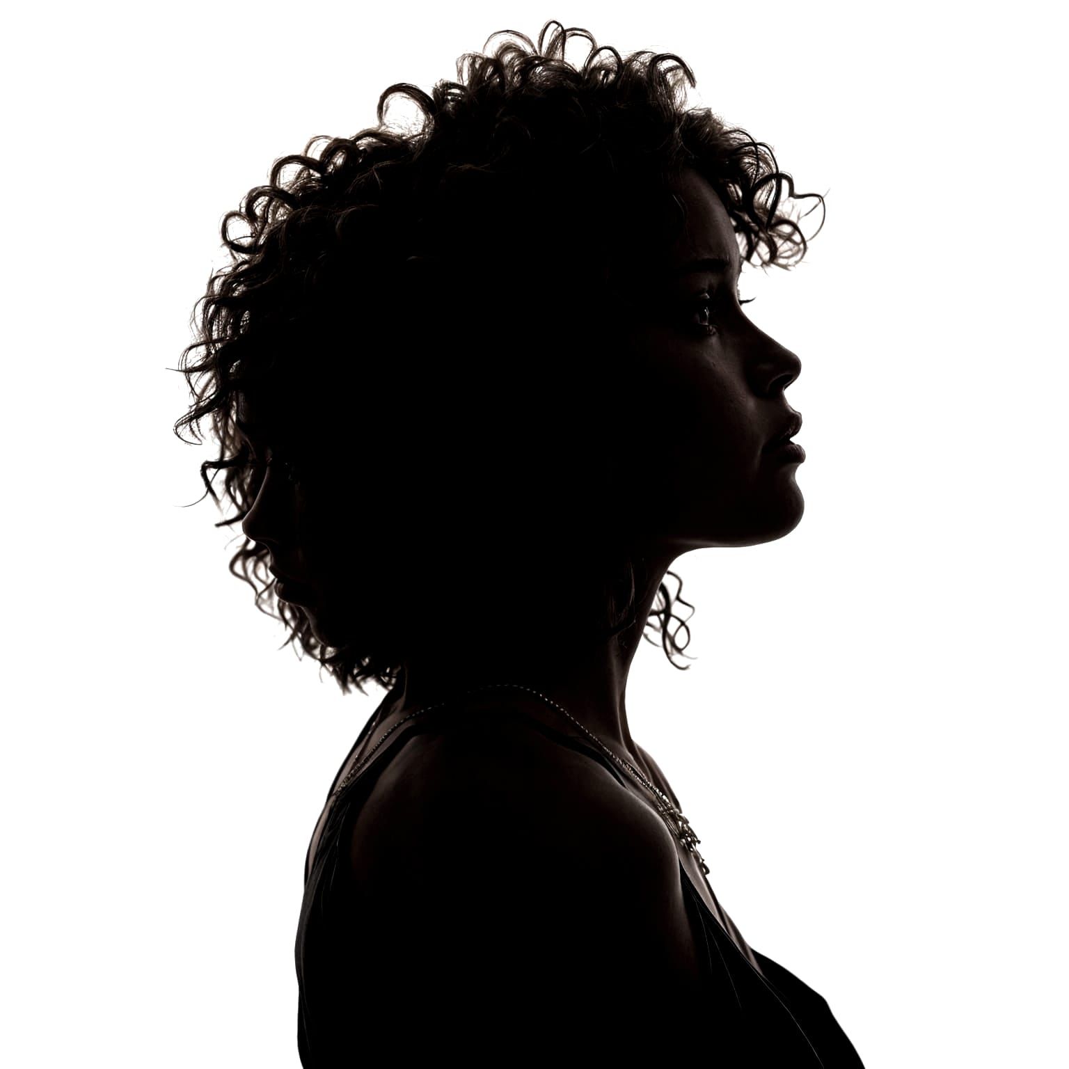 A silhouette of a woman with curly hair, facing right, in a ...