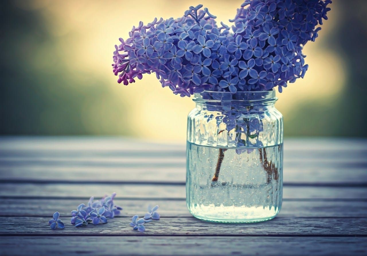 Elegant Blue Lilacs in Antique Glass Jar with Soft Focus