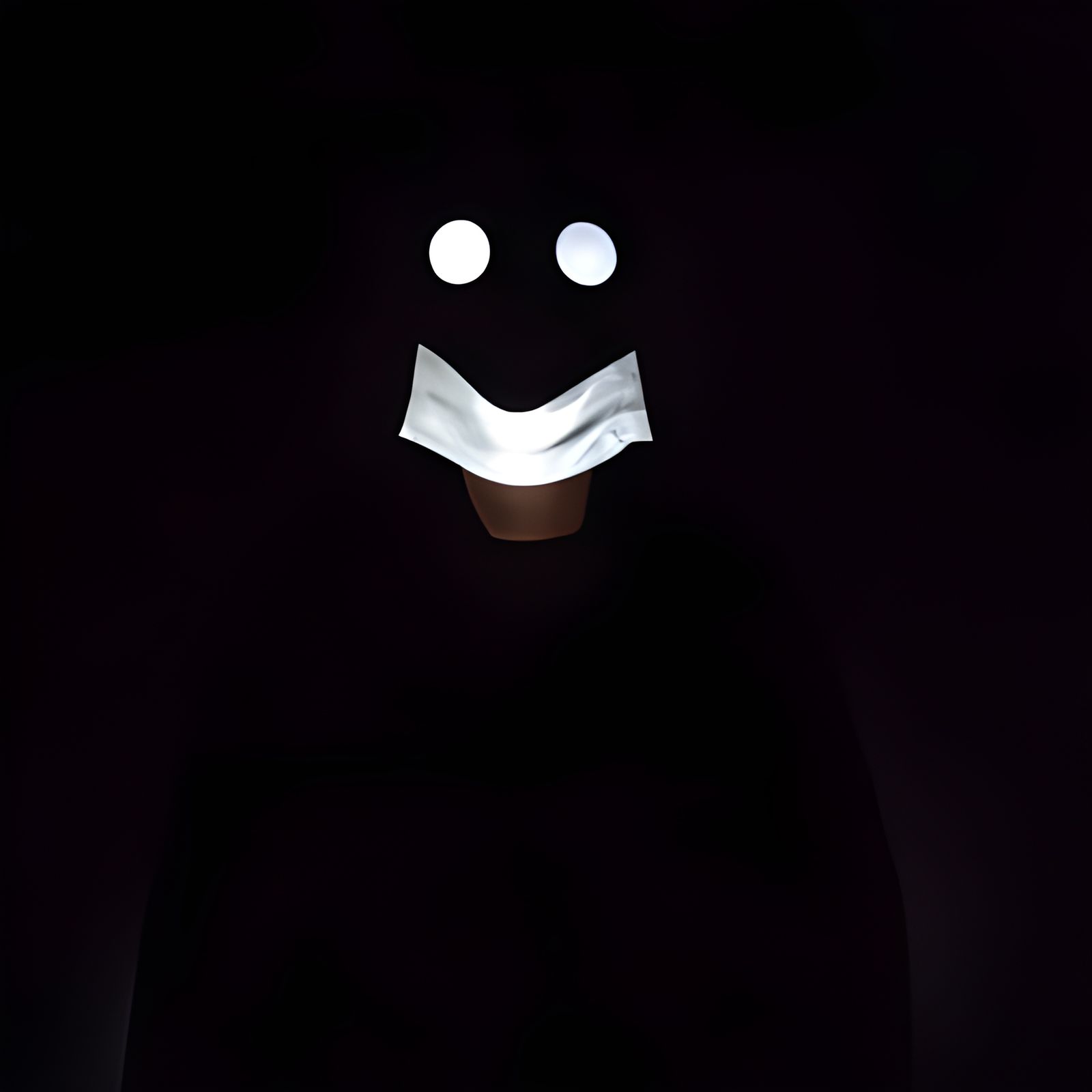 Figure in Darkness Wearing Smiley Face Mask