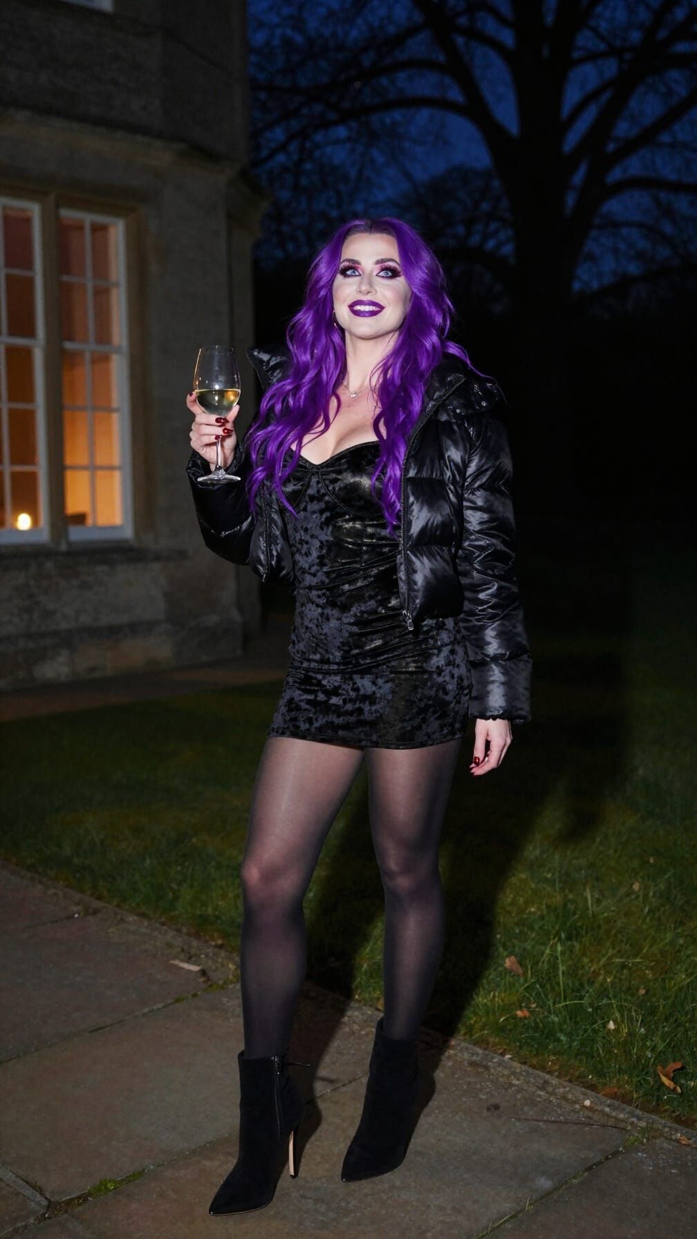 Woman Enjoys Wine on Mansion Terrace at Night