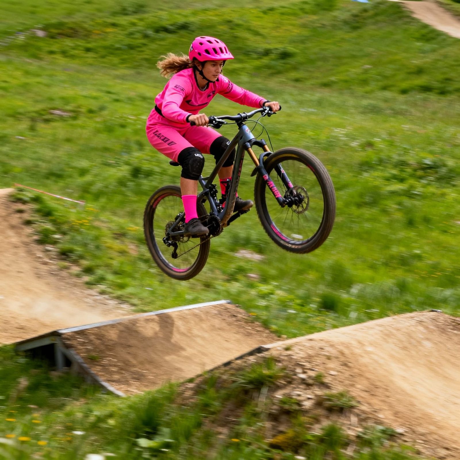 Female Mountain Biker Soars Over Double Jump in Action Shot