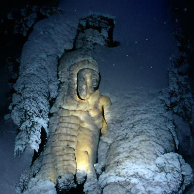 Snowy Ancient Statue Under Night Sky