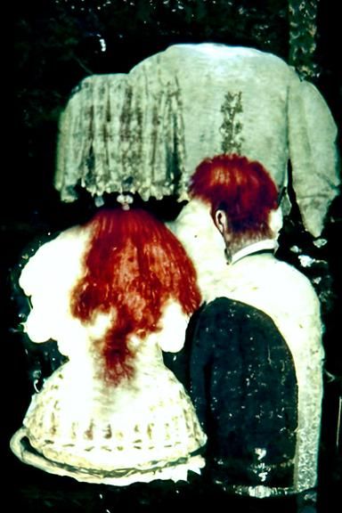 a married couple from behind, as seen in a séance of the ear...
