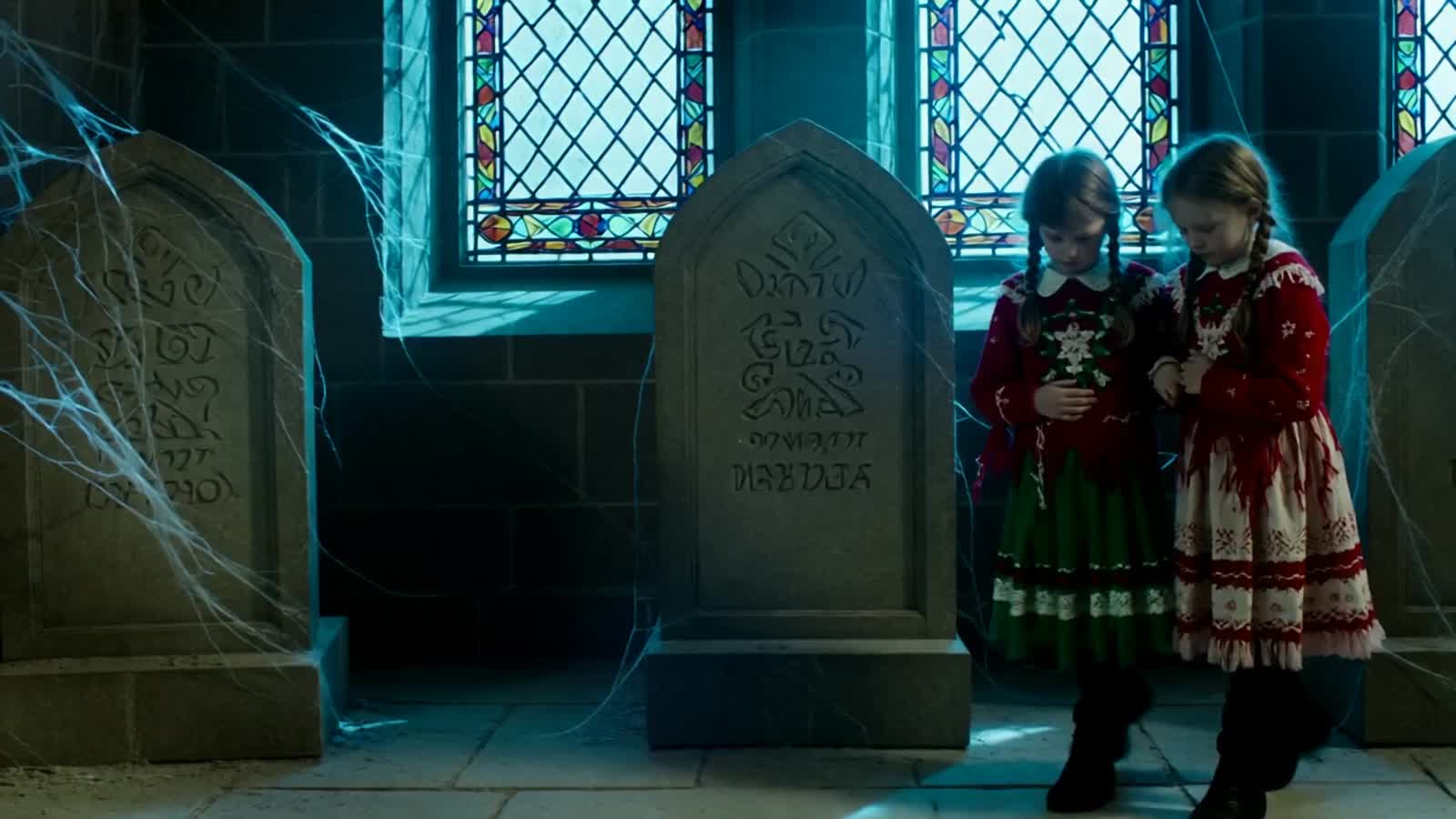 Chilling ghost-children in faded Christmas clothing in a cold and eerie Crypt