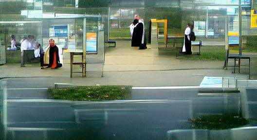 Catholic Priest at a bus stop.