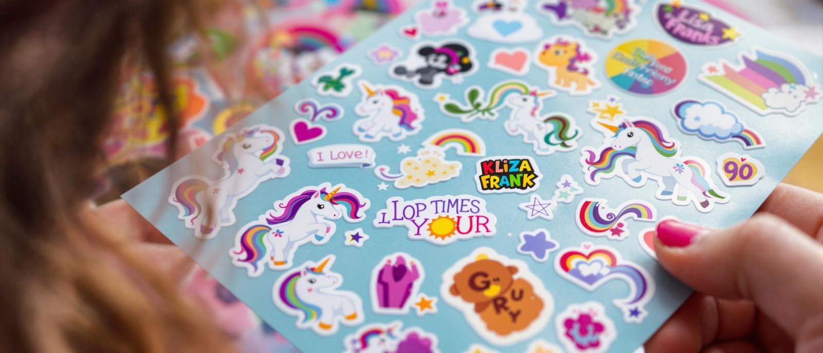 an 80's teen girl getting Lisa Frank unicorn stickers as a gift, closeup on the sticker sheets  by @Feeling Creative