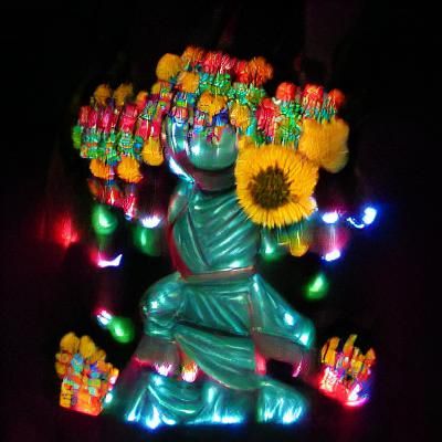 a dancing buddha with many lights and flowers