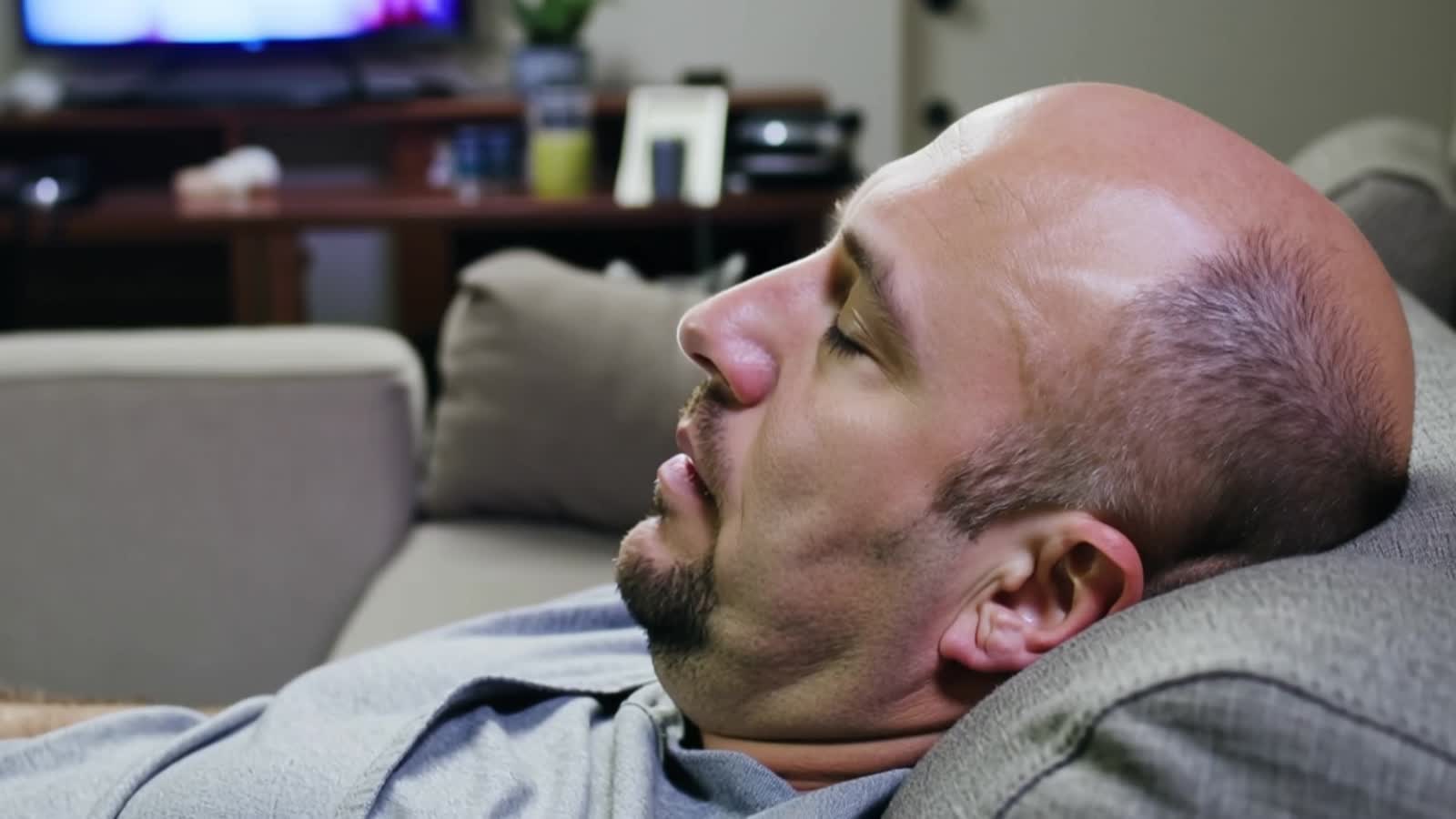 This bald man is sleeping soundly when a koala runs out of nowhere, slaps him in the face and runs away again