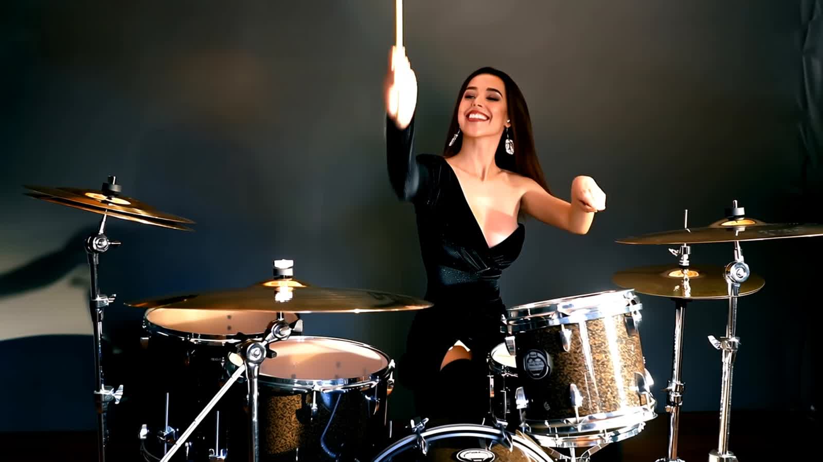 an attractive lady behind the drums