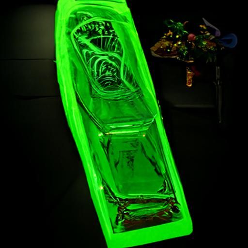 Uranium glass coffin and ultraviolet light on black velvet