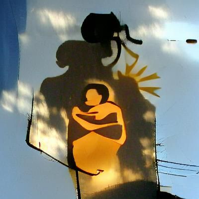 silhouette of mother holding a baby on a sun lit street