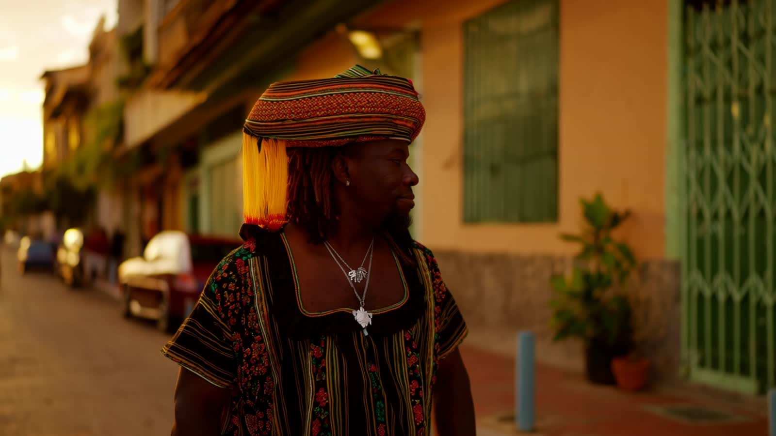 a voodoo walking down a Cuban street, doing the sunset watching the people mil around him