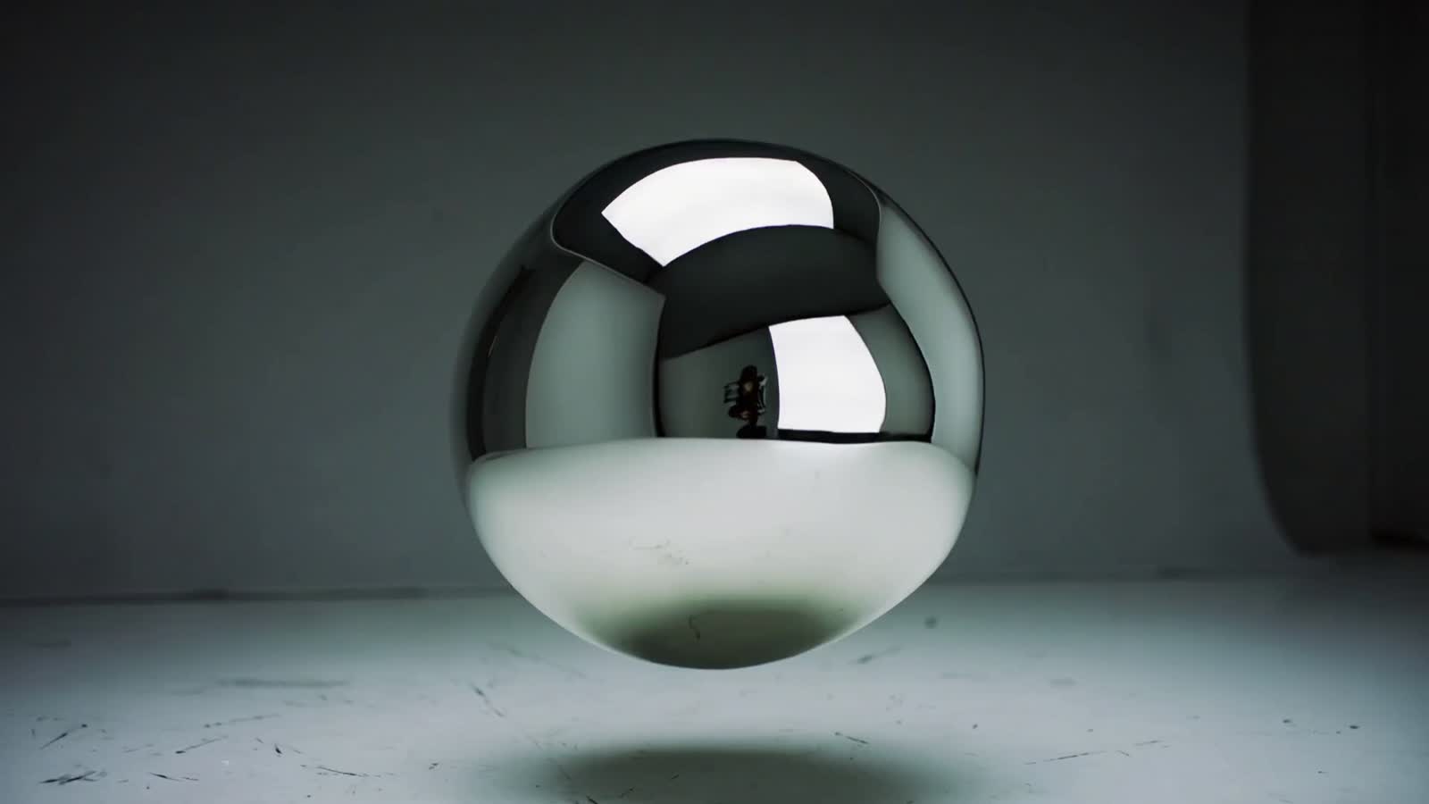 A floating blob of mirror-like liquid metal continuously morphing into new shapes as the camera slowly rotates around it...