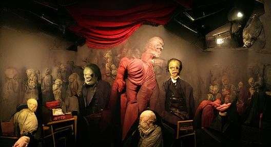 A dark room filled with detailed wax figures