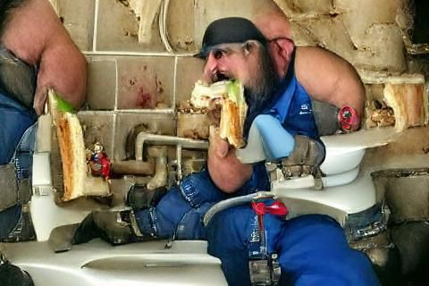 Plumber from hell eating a sandwich.