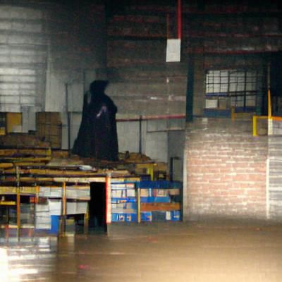 Dark figure hiding in a warehouse