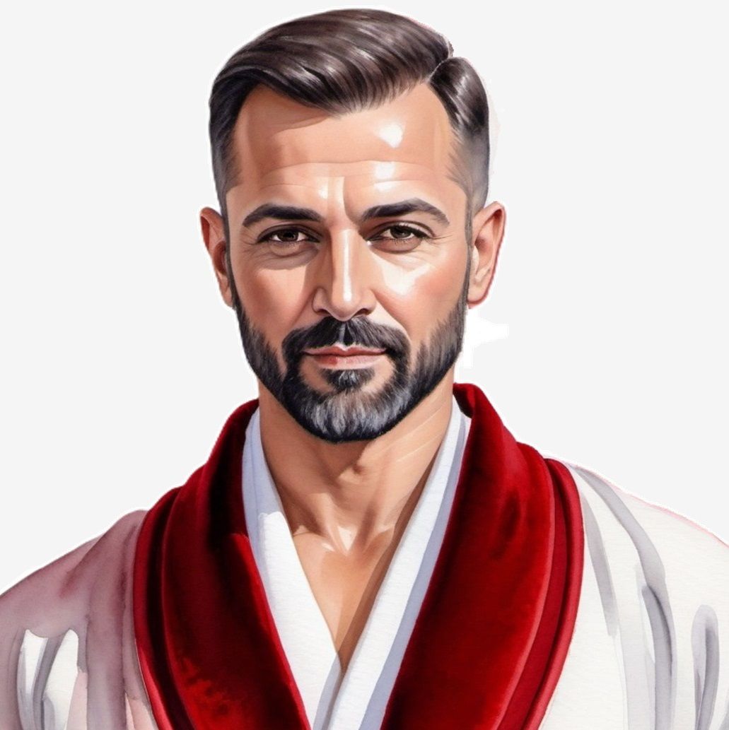 A handsome man with greying   hair and beard wearing a   whi...