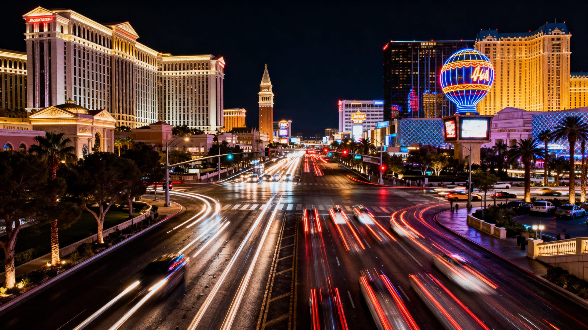 A spectacular night view of the Las Vegas Strip, with its extravagant hotels and colorful lights illuminating the skyline, creating an elect...