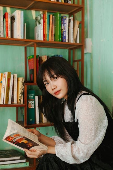 This girl is waliking on the road and reading a book