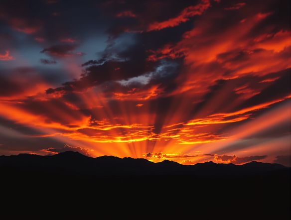 A dramatic sunset over a silhouetted mountain range. Fiery orange and deep red clouds streak across the sky, casting long shadows. Sunbeams pierce through the clouds. Cinematic, epic lighting.
