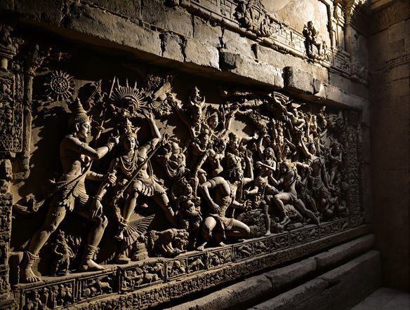 An epic bas-relief depicting a scene from the Ramayana, featuring divine warriors and mythical creatures carved into weathered stone, dramatic lighting, ancient temple wall.