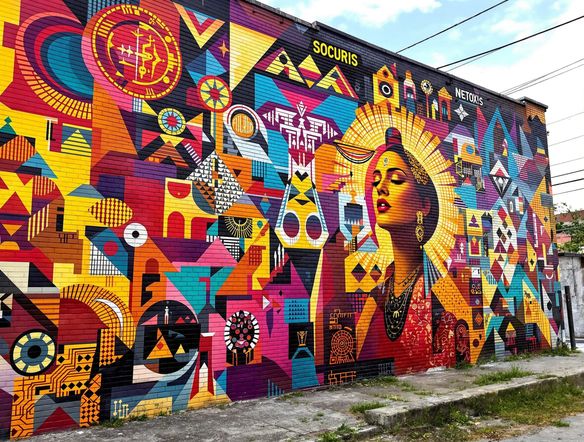 A colorful and dynamic South American street art mural on a brick wall, featuring abstract geometric patterns, indigenous motifs, and social commentary elements. South American street art AI, digital muralism tool.