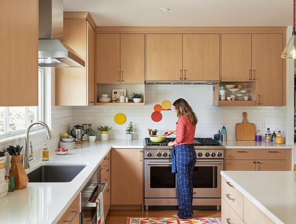 A bright, modern kitchen with a vibrant color palette, showcasing a blend of natural wood, stainless steel appliances, and colorful decor, creating a warm and inviting atmosphere.