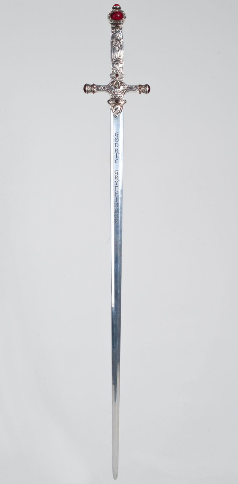 Sword of Gryffindor, silver crossguard, with a red leather-wrapped handle, with a silver pommel with a ruby imbedded in it. The blade is pol...